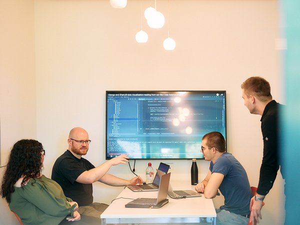 hsrt-Studierende im Besprechungsraum Eine Gruppe Studierender lernt mit Notebooks und Notizen in einem Arbeitsraum mit Whiteboard und blauem Bildschirm