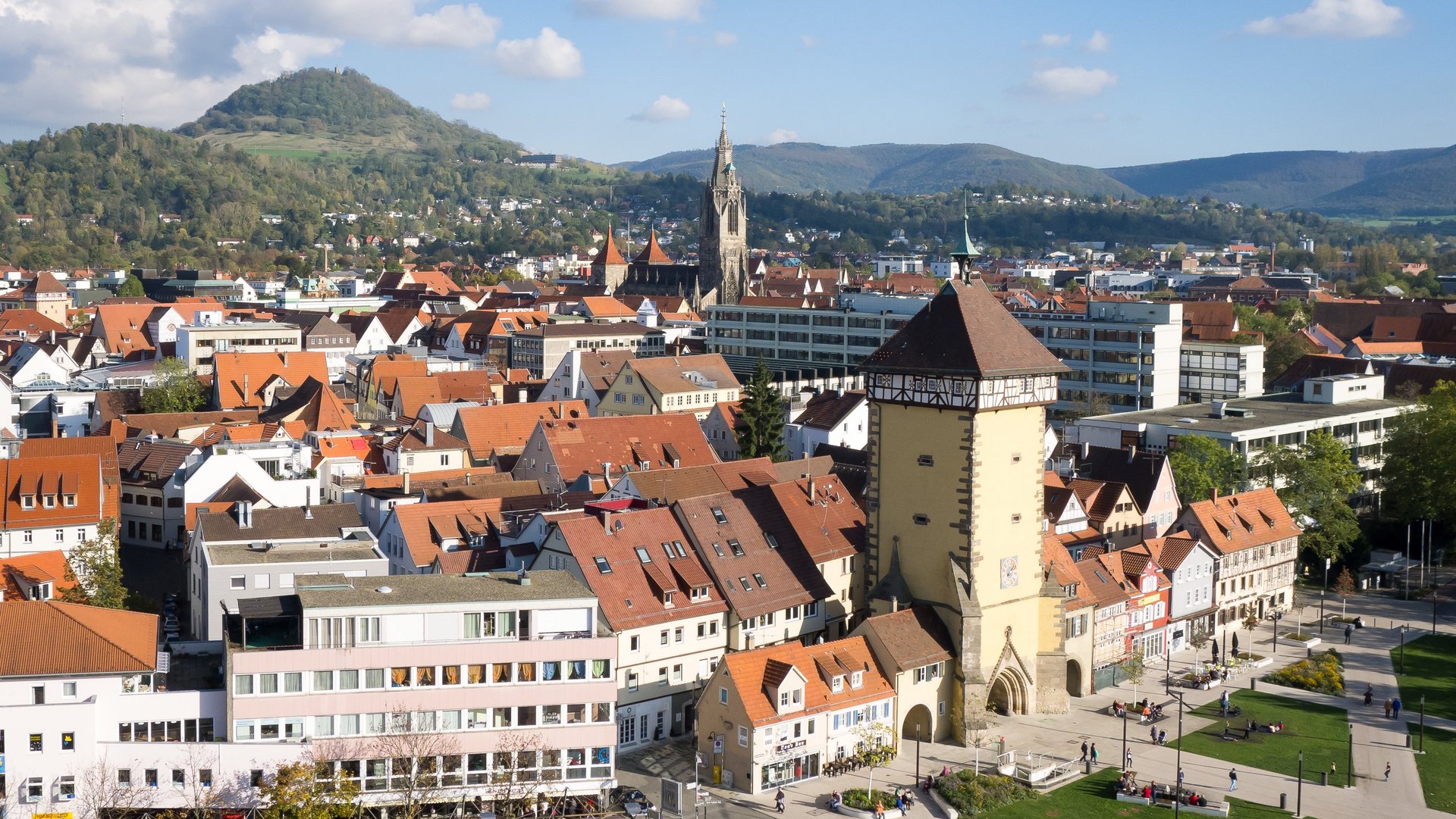 Vogelansicht der Reutlinger Innenstadt mit Stadttor und Albtrauf im Hintergrund